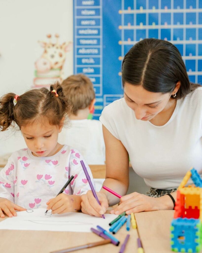 Adventure Learning Center before and after school child coloring with teacher guidance